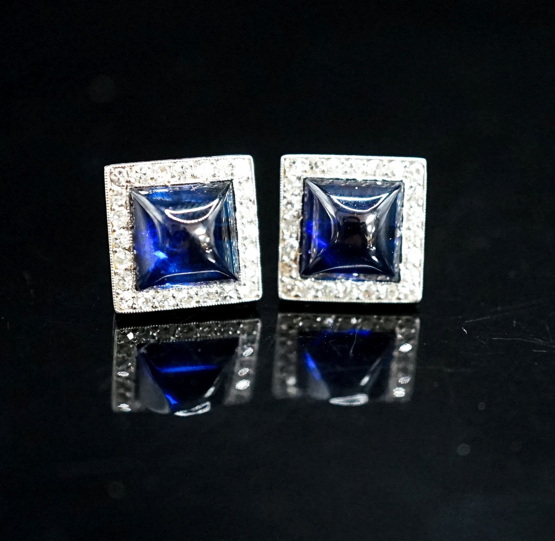 A pair of white metal and blue cabochon set square ear studs with diamond set borders, 11mm, gross weight 5.7 grams.